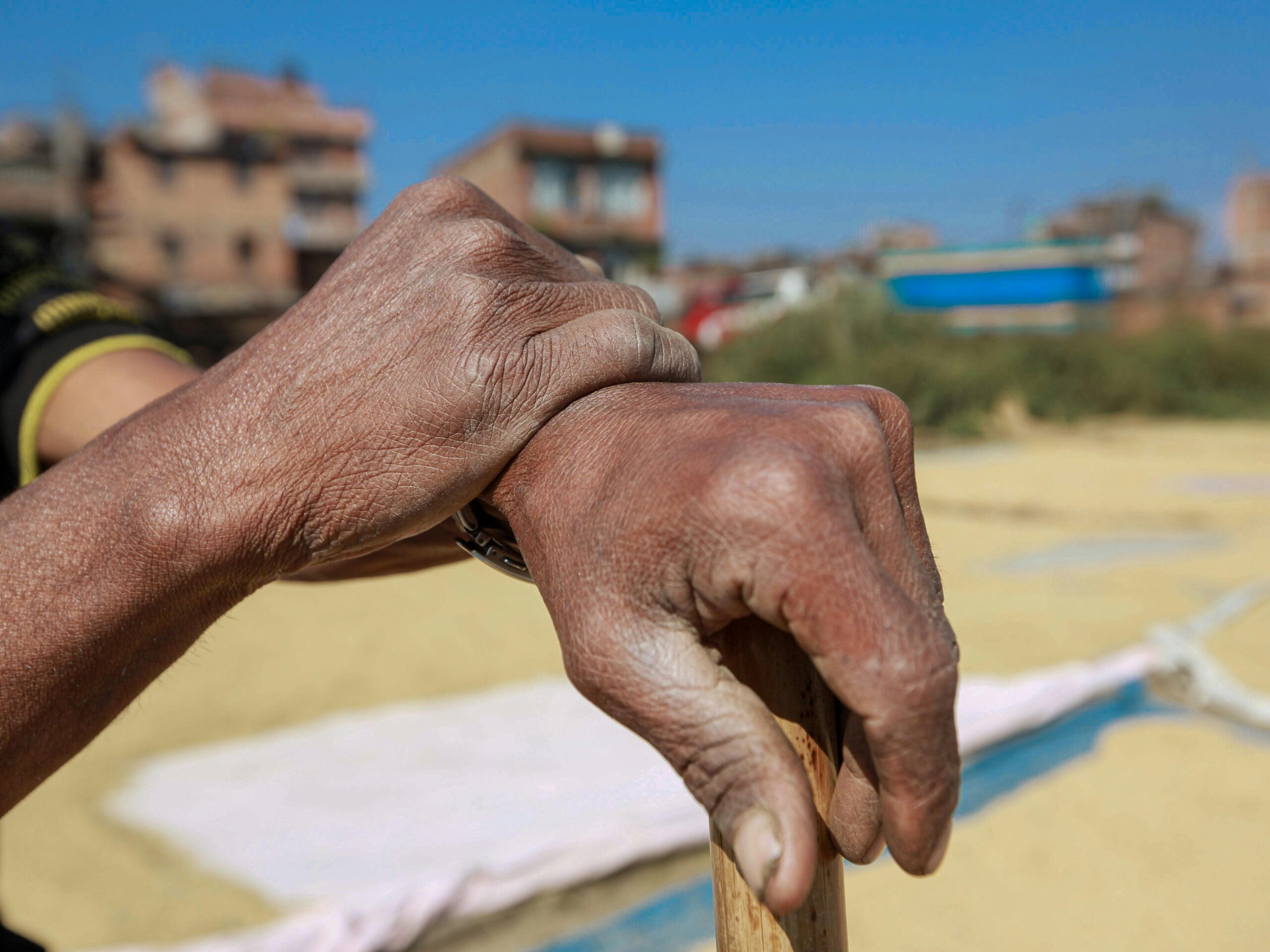 Cuando tu mejor esfuerzo no es suficiente para ellos, pero siempre es suficiente para Él Detailed focus on senior hands gripping a stick, showing aged skin and wrinkles.